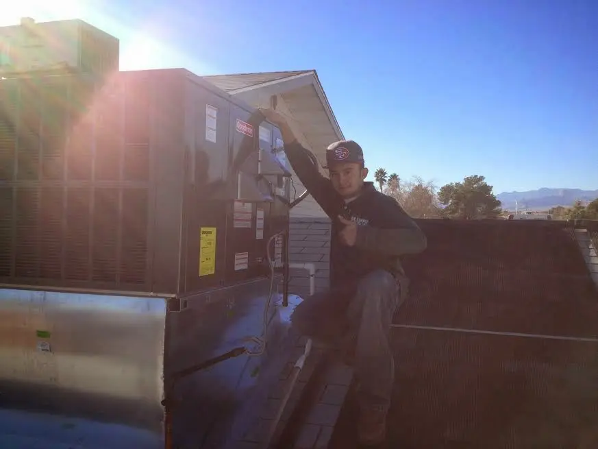 HVAC technician performing Air Duct Cleaning on a rooftop unit in Klamath Falls